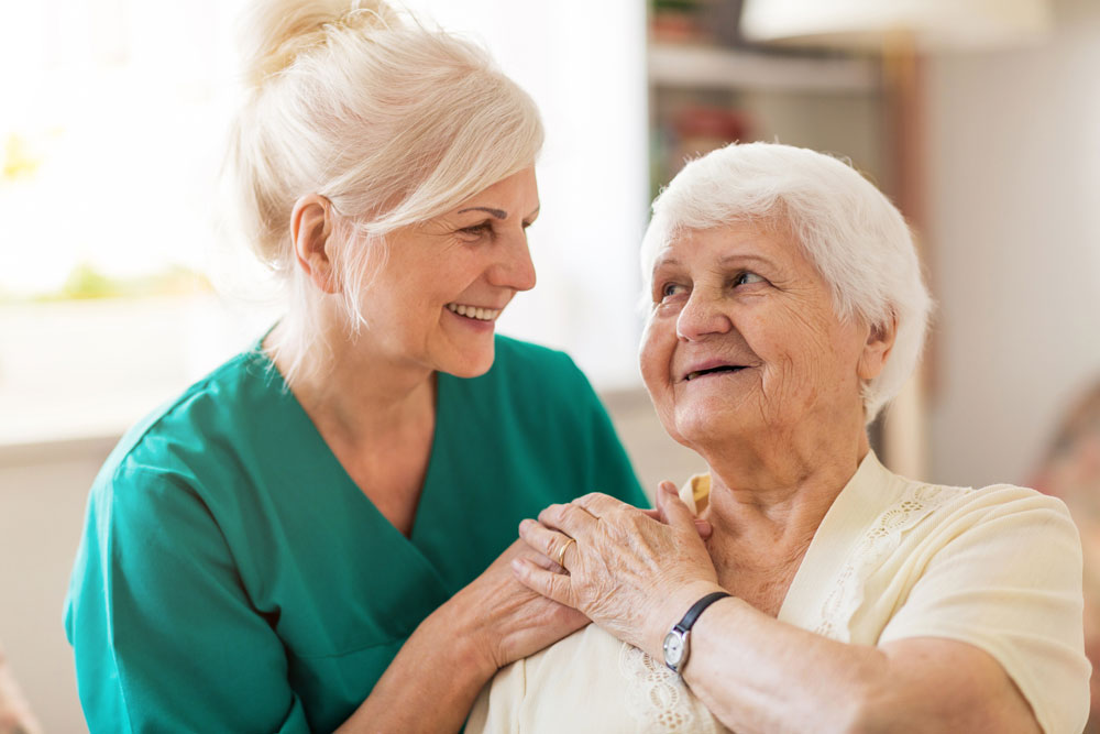 nurse comforting older woman